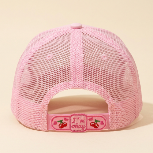 Back view of pink Curbs N Kisses trucker hat showing cherry bandage patch on a cream background